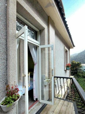 A wooden deck with a glass door leading to a balcony. - Shuanghui Garden B&B (New Taipei City)