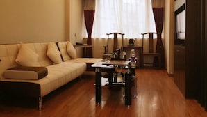 A modern living room with a sofa, a coffee table, and a TV. - Zhu Ying Art Hotel (Guangzhou)