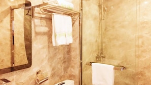 A bathroom with a glass-enclosed shower, a sink with a mirror, and a towel rack with folded towels. - Zhu Ying Art Hotel (Guangzhou)