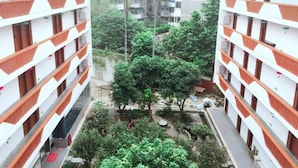 A multi-story hotel with balconies, a courtyard with trees, and a view of surrounding buildings. - Zhu Ying Art Hotel (Guangzhou)