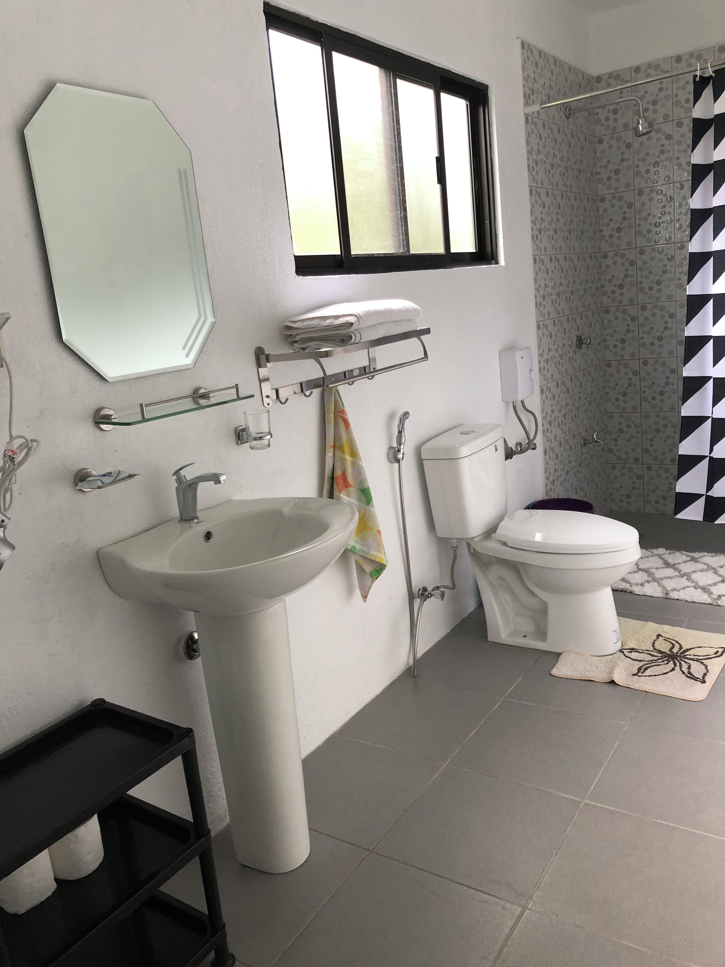A bathroom with a sink, toilet, and shower.