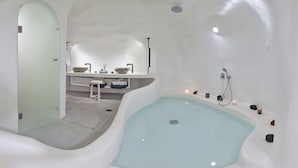 Un baño moderno con una bañera grande, un tocador con lavabo y una zona de ducha.