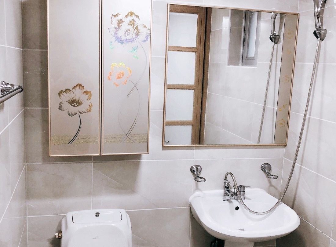 Un baño con un lavamanos blanco, un espejo y una ducha.