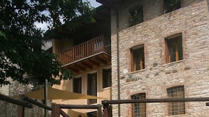 Un escalier en pierre menant à un bâtiment doté d’un balcon.