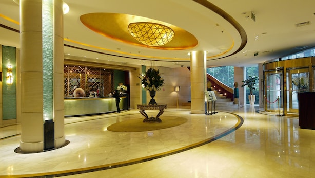 A spacious lobby with a central decorative table, a reception desk, and a staircase leading to upper floors. - Enjoyable Stars Hotel Chengdu (Chengdu)