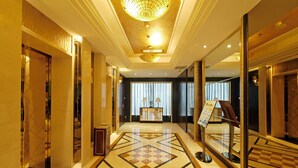 A hotel lobby with a geometric patterned floor, a reception desk, and a chandelier. - Enjoyable Stars Hotel Chengdu (Chengdu)