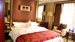 A hotel room with a large bed, two bedside tables, a chair, a small round table, and a window with curtains. - Enjoyable Stars Hotel Chengdu (Chengdu)