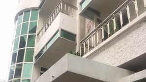 A multi-story hotel with a modern design, featuring balconies with metal railings and large windows.