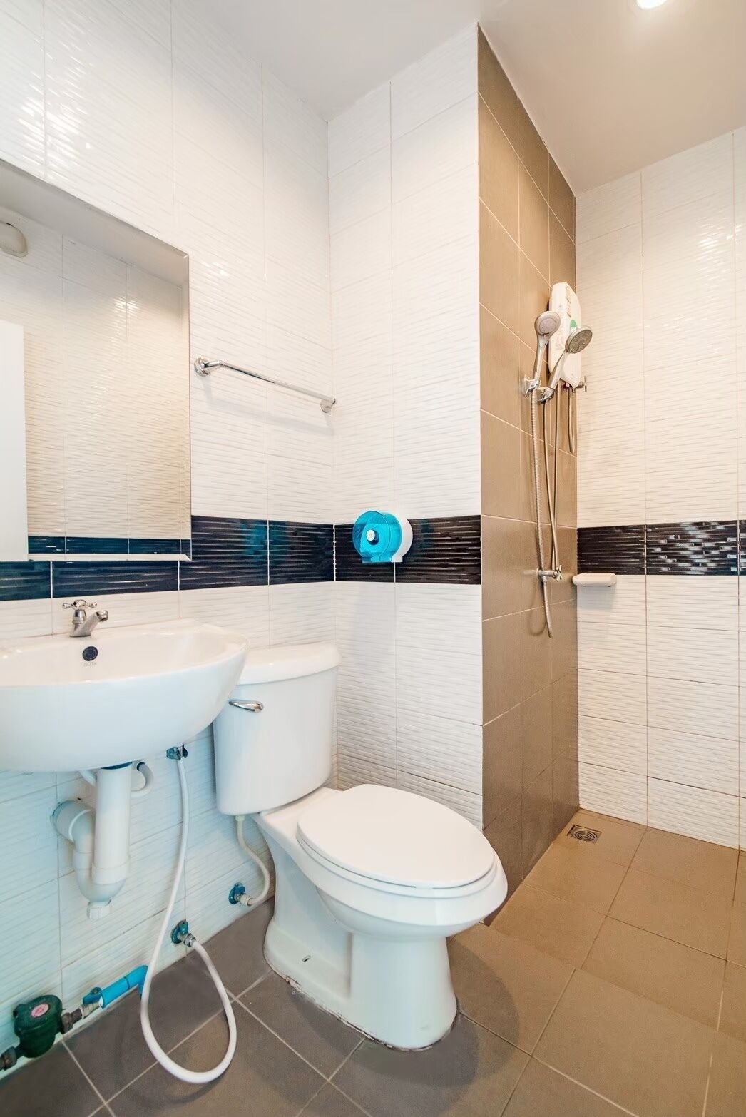 Uma casa de banho moderna com lavatório, sanita e chuveiro.