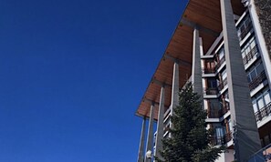 A multi-story building with balconies and a clear blue sky. - Hotel Edelweiss Candanchu (Aisa)