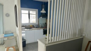 A kitchen with white cabinets, a window, and a white partition. - VILLA SOLARIS Independent studio in villa with pool (Alpes-Maritimes)