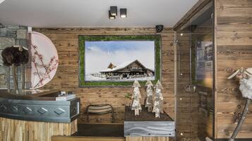 A reception desk with a wooden design, a framed picture of a snowy building, and a wooden wall with a number above it.
