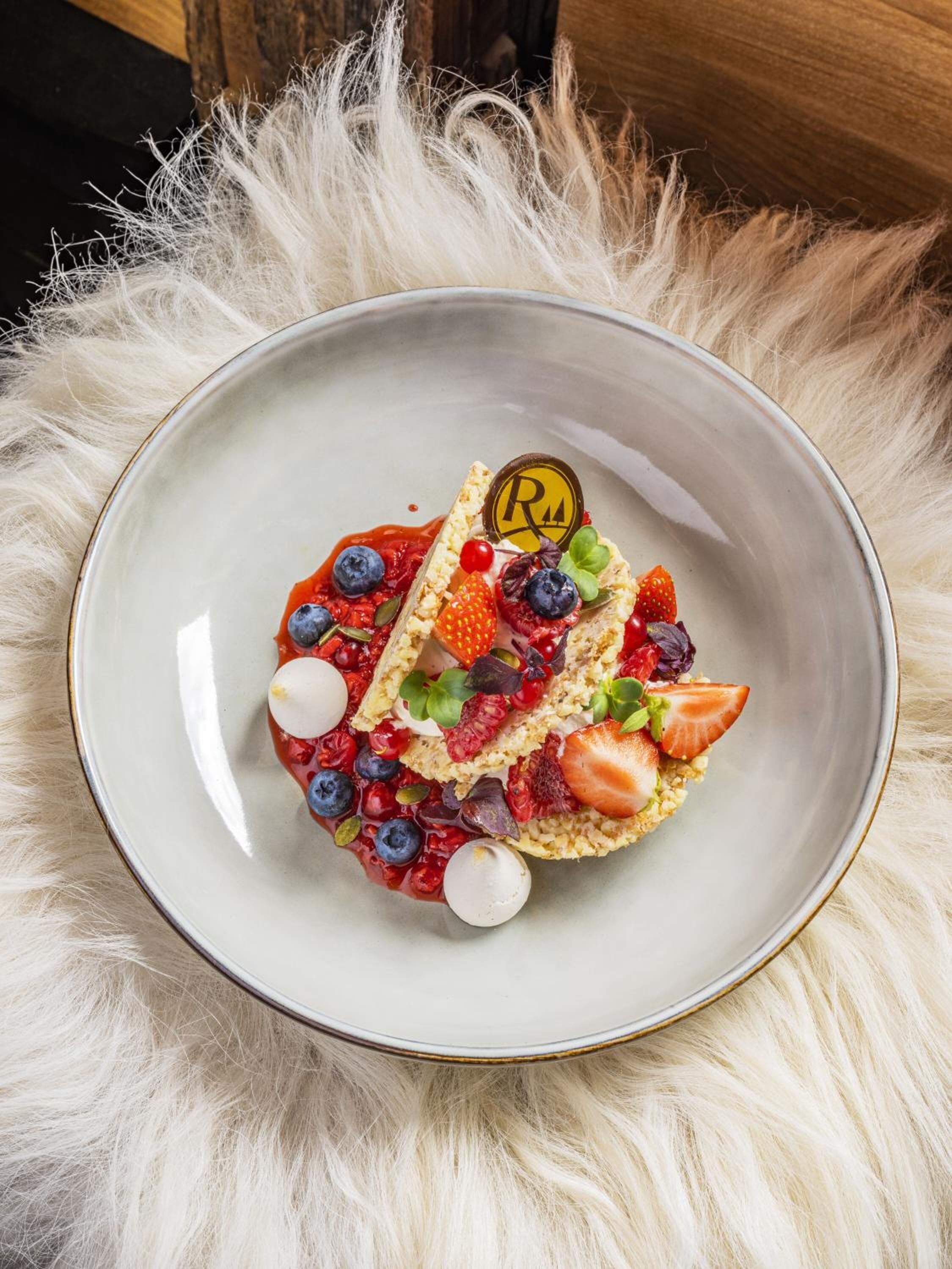 A dessert on a ceramic plate with a fluffy white surface underneath.