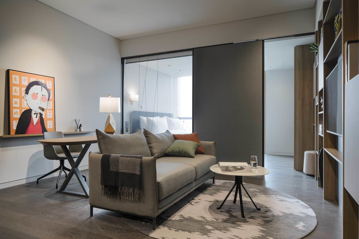 Un salon moderne avec un canapé, une table basse et un tableau accroché au mur.