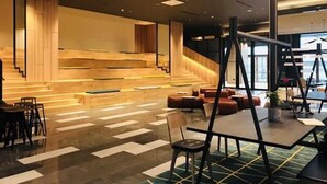 Ein modernes Interieur mit Treppe, Sitzecke und Tischen.