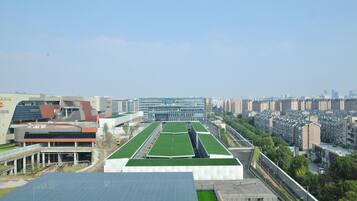 A high-rise building with a rooftop garden and solar panels.