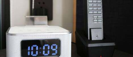 A digital clock displaying 10:09, a charging station, and a remote control.