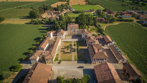 An aerial view of a historic estate with a central courtyard, surrounded by buildings and vineyards. - Palazzo Turro B&B (Podenzano)