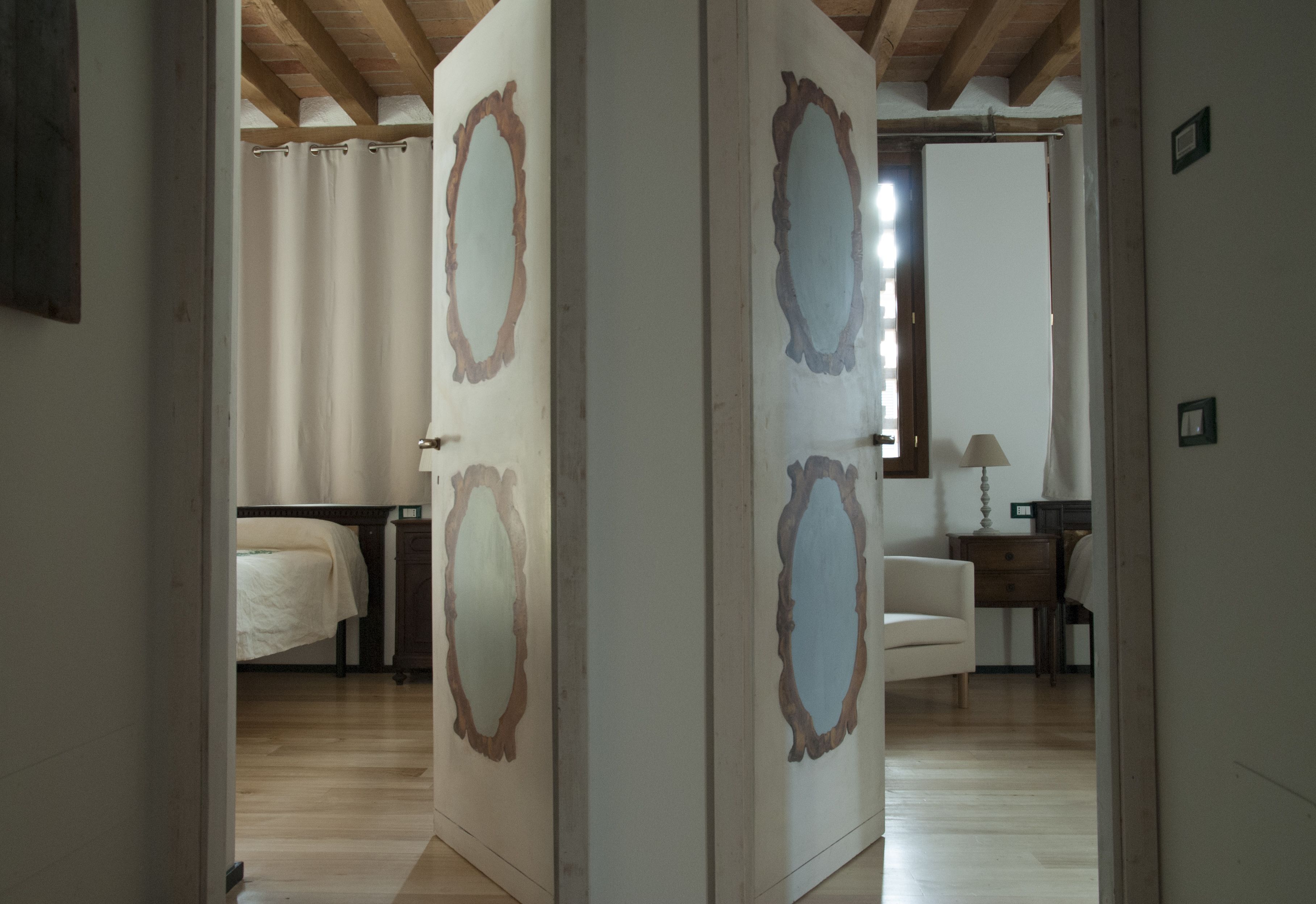 A hotel room with a wooden ceiling, a bed, a desk, and a chair.