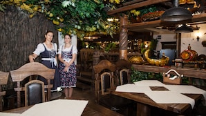A rustic interior with wooden furniture, a stone wall, and decorative plants. - Egorkino Hotel (Astana)