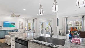 A modern kitchen with a built-in dishwasher, a double sink, and a large island.