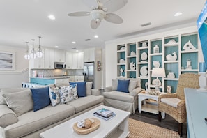 A modern living room with a sofa, coffee table, and decorative shelves.