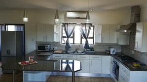 A modern kitchen with a central island, stainless steel appliances, and pendant lighting.