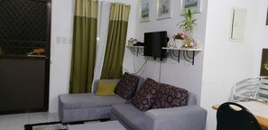 Three-Bedroom Suite with Balcony | Living area | Flat-screen TV - Homestay at Camella Homes Bohol (Tagbilaran)