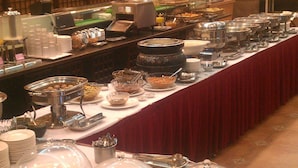 A buffet setup with various food items and serving utensils. - Nikaido Bussiness Hotel (Minxiong)
