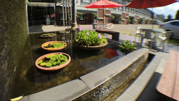 A water feature with planters, outdoor seating, and a building in the background. - Nikaido Bussiness Hotel (Minxiong)