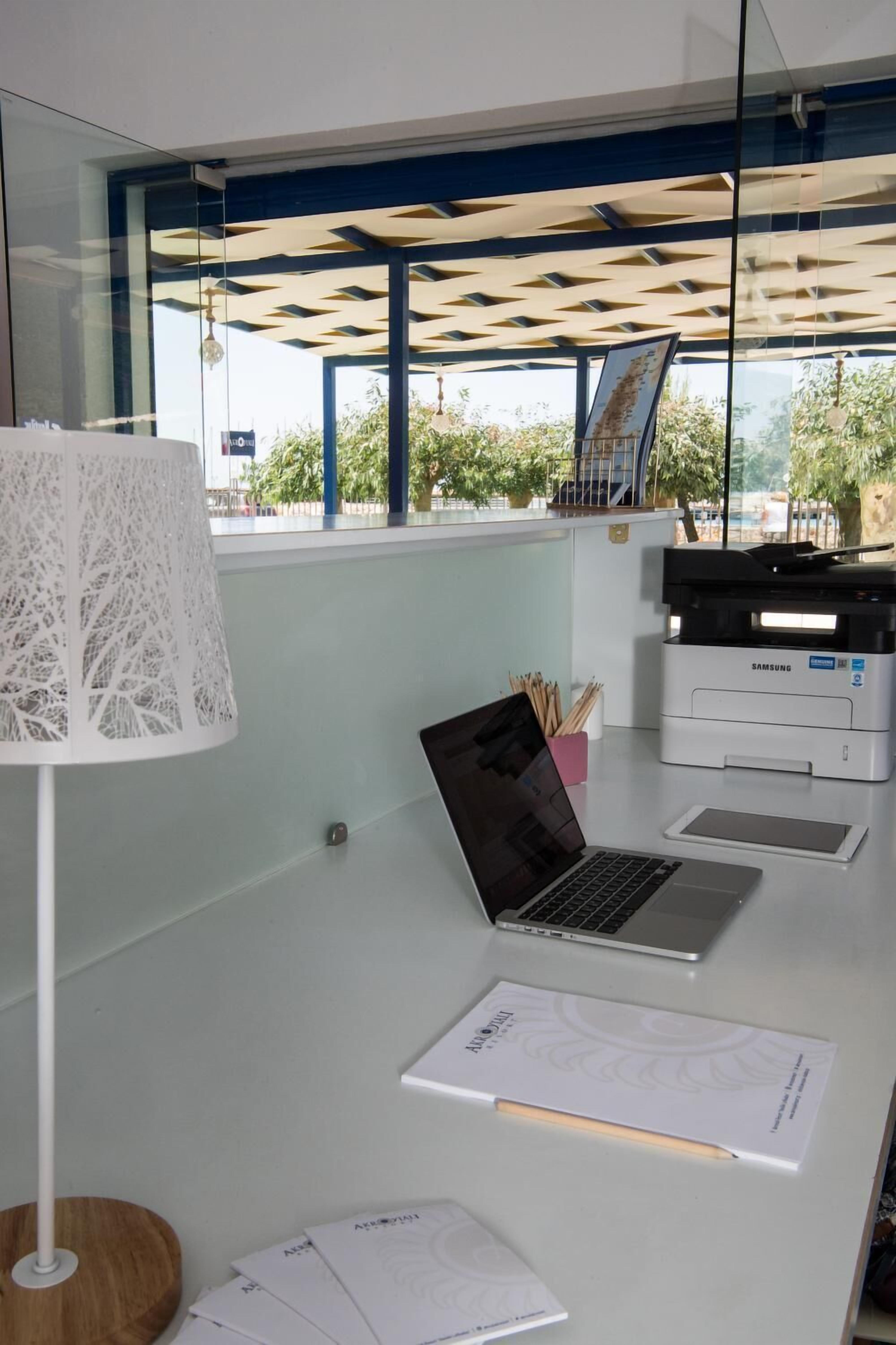 Un bureau moderne, équipé d’un ordinateur portable, d’une imprimante et de documents.
