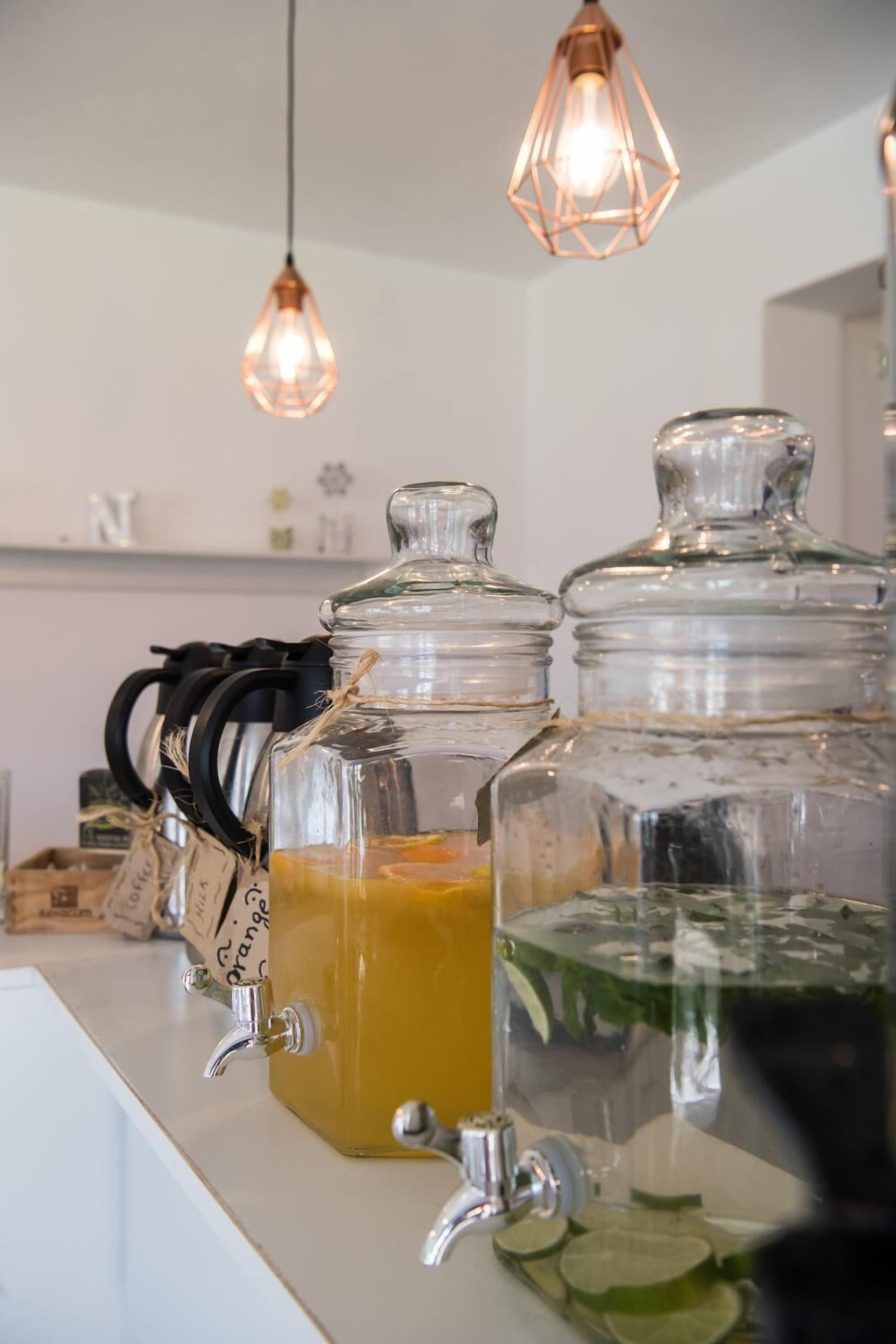 A row of glass dispensers with different colored liquids, each with a tap.