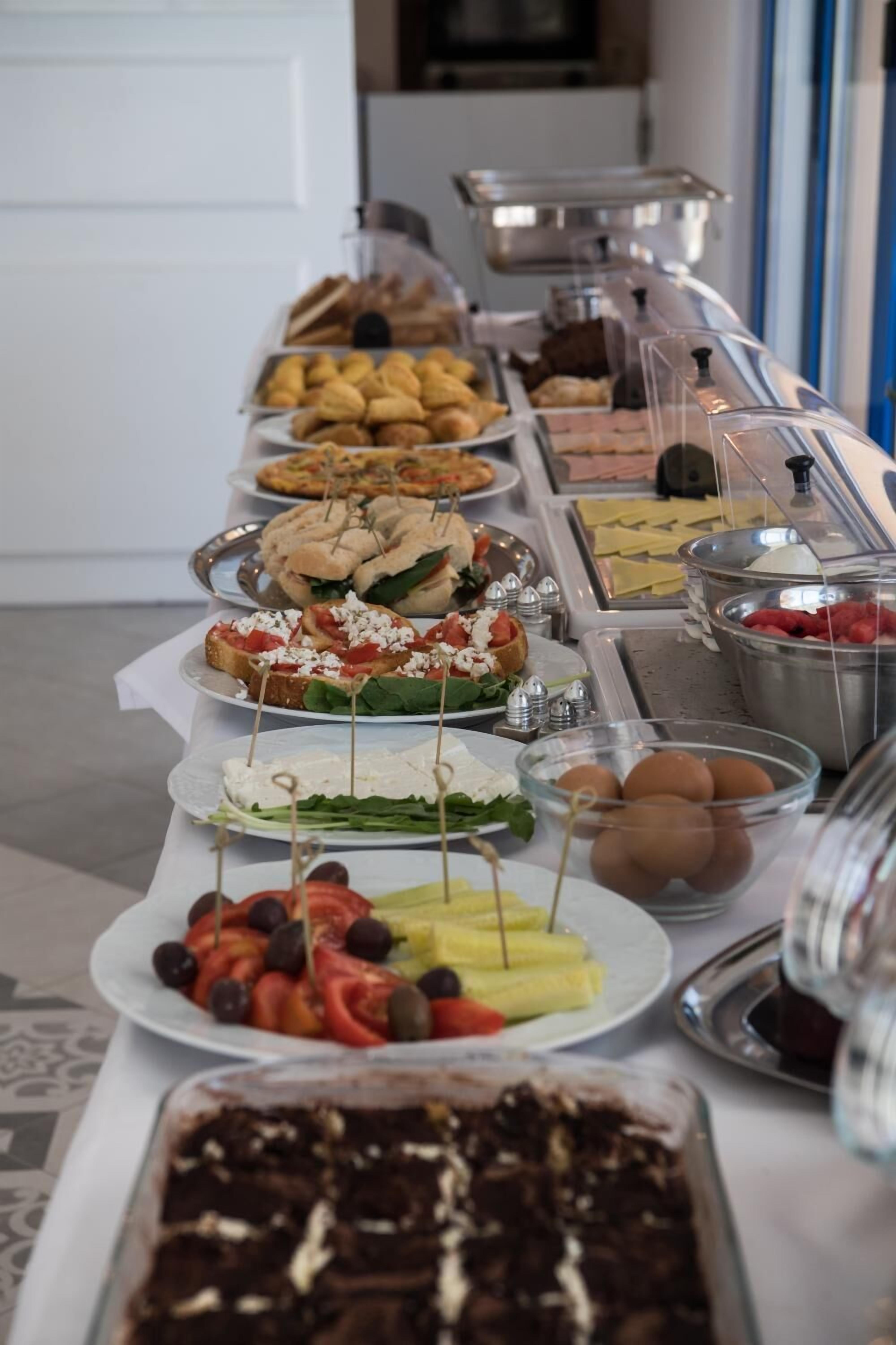 A buffet with various food items including sandwiches, salads, and desserts.