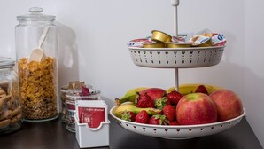 A breakfast setup with a bowl of fruit, a jar of cereal, and a carton of milk. - B&B Civico 41 Salerno (Salerno)