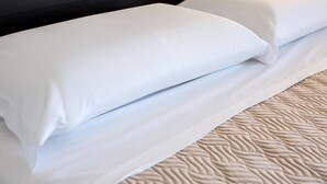 A neatly made bed with white linens and a textured beige bedspread. - B&B Civico 41 Salerno (Salerno)