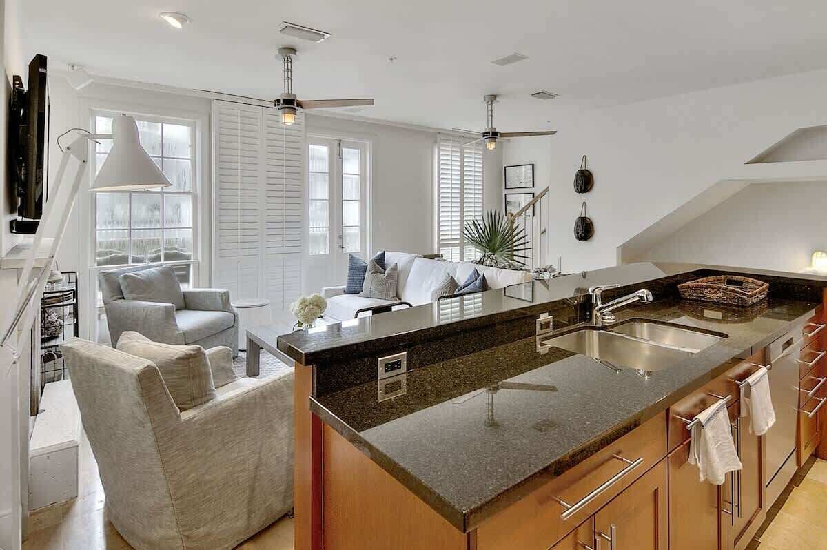 A modern kitchen with a central island, built-in appliances, and a dining area with a sofa and chairs.
