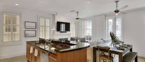 A spacious kitchen with a central island, wooden cabinetry, and a dining area with a bench.