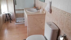Une salle de bain équipée de toilettes, d’un lavabo et d’une douche.