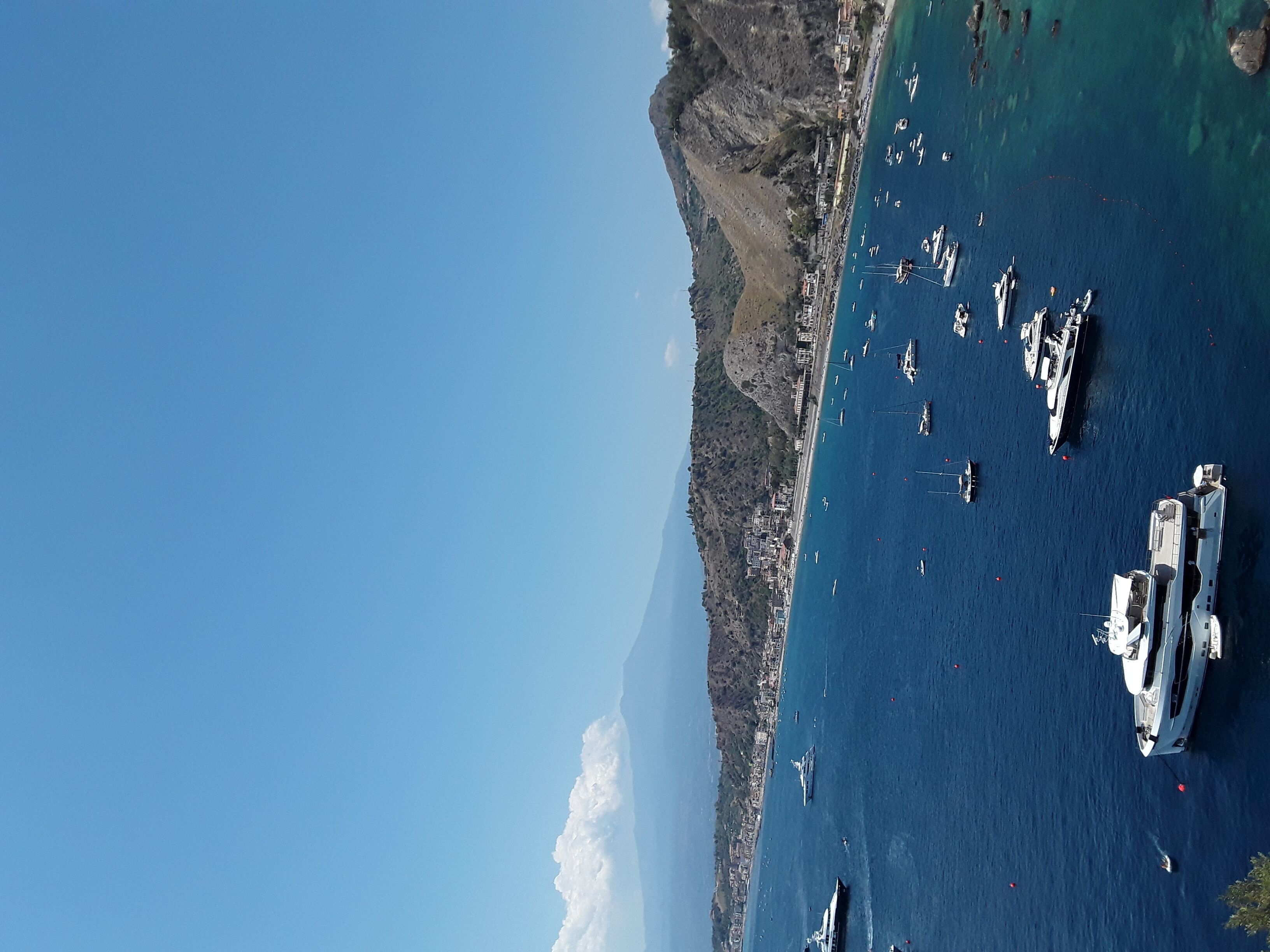 Un pueblo costero con un puerto deportivo lleno de barcos.