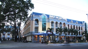 A hotel with a large arched entrance, multiple balconies, and a sign reading "KHACH SAN SUY NAKON". - Quy Nhon Hotel (Quy Nhon)