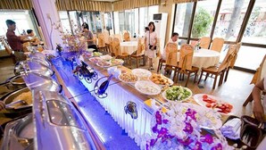 A buffet setup with various food items and a long serving counter. - Quy Nhon Hotel (Quy Nhon)