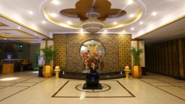 A lobby with a central decorative fountain, patterned wall, and a ceiling with a circular light fixture. - Chengdu Tianfu Pretty Hotel (Chengdu)