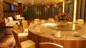 A banquet hall with round tables, white chairs, and a central floral arrangement. - Chengdu Tianfu Pretty Hotel (Chengdu)