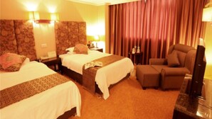A hotel room with two beds, a sofa, a desk, and a television. - Chengdu Tianfu Pretty Hotel (Chengdu)