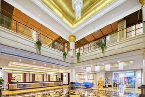 A spacious lobby with a reception desk, seating area, and a large chandelier. - Haiwaihai International Hotel (Hangzhou)