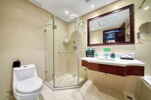 Une salle de bain moderne avec une douche à parois de verre, des toilettes blanches et un meuble-lavabo avec un miroir.