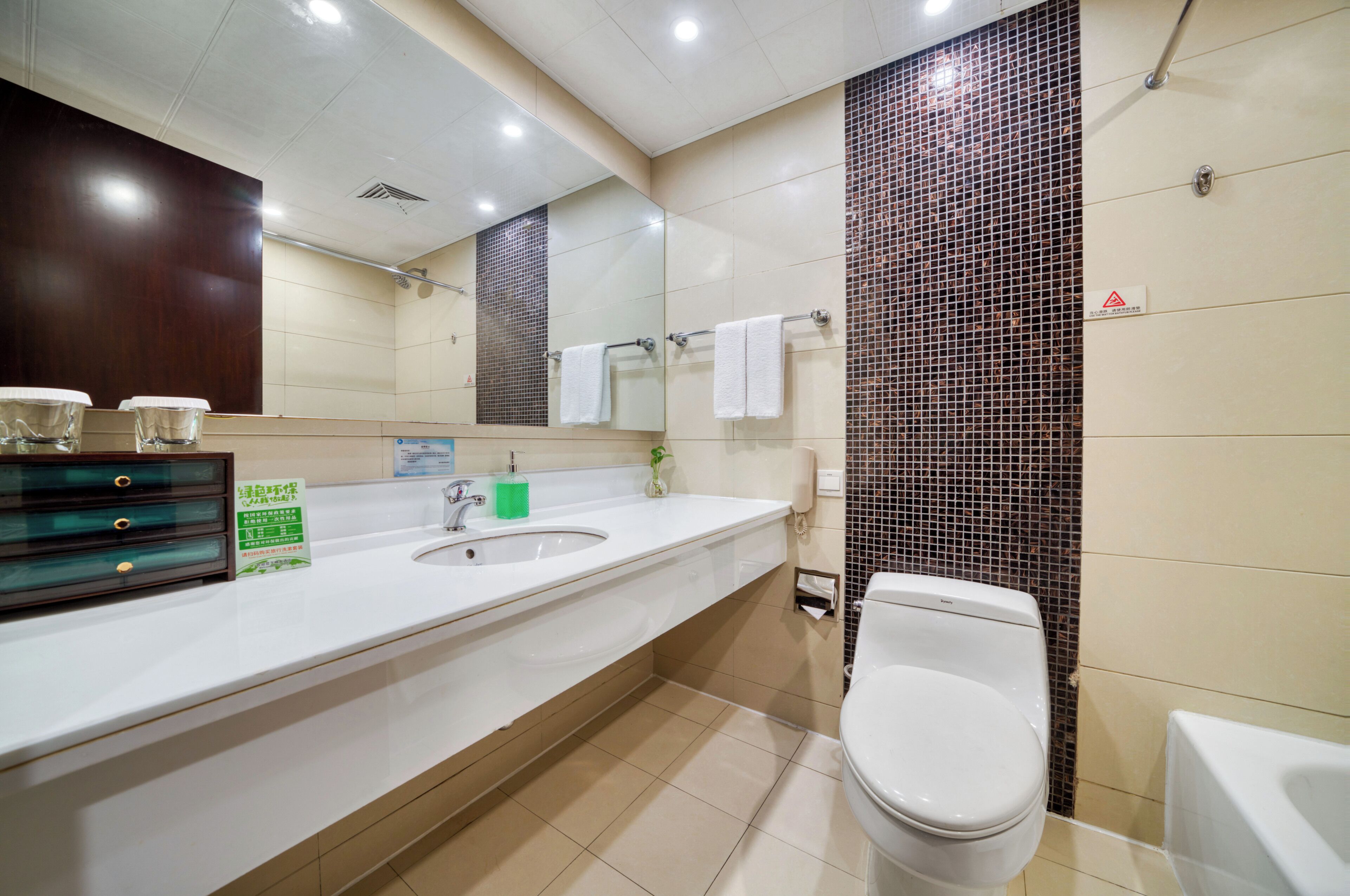 A modern bathroom with a white sink, a mirror, a toilet, and a shower area.