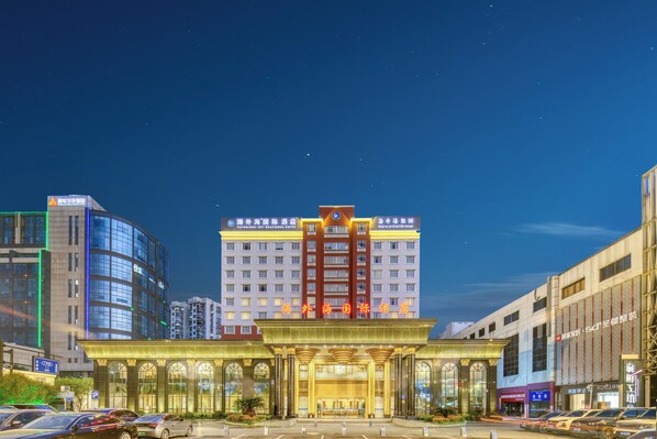A hotel with a prominent entrance, multiple floors, and a parking lot. - Haiwaihai International Hotel (Hangzhou)