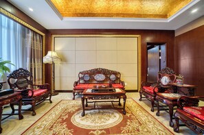 A traditional room with a sofa set, a table, and a lamp. - Haiwaihai International Hotel (Hangzhou)
