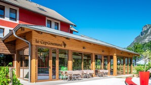 Een restaurant met een houten gevel en terras.